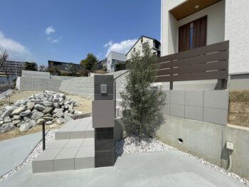 大阪吹田市のシンプルなエクステリア門柱まわりの様子です。シンプルな黒の大判タイルで門柱を作ってインターホンとポストを設置しました。