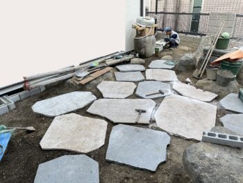 提案したお庭のデザインを基に石の平板の間に大きめの目地をバランスよく取りながら配置をしていきます